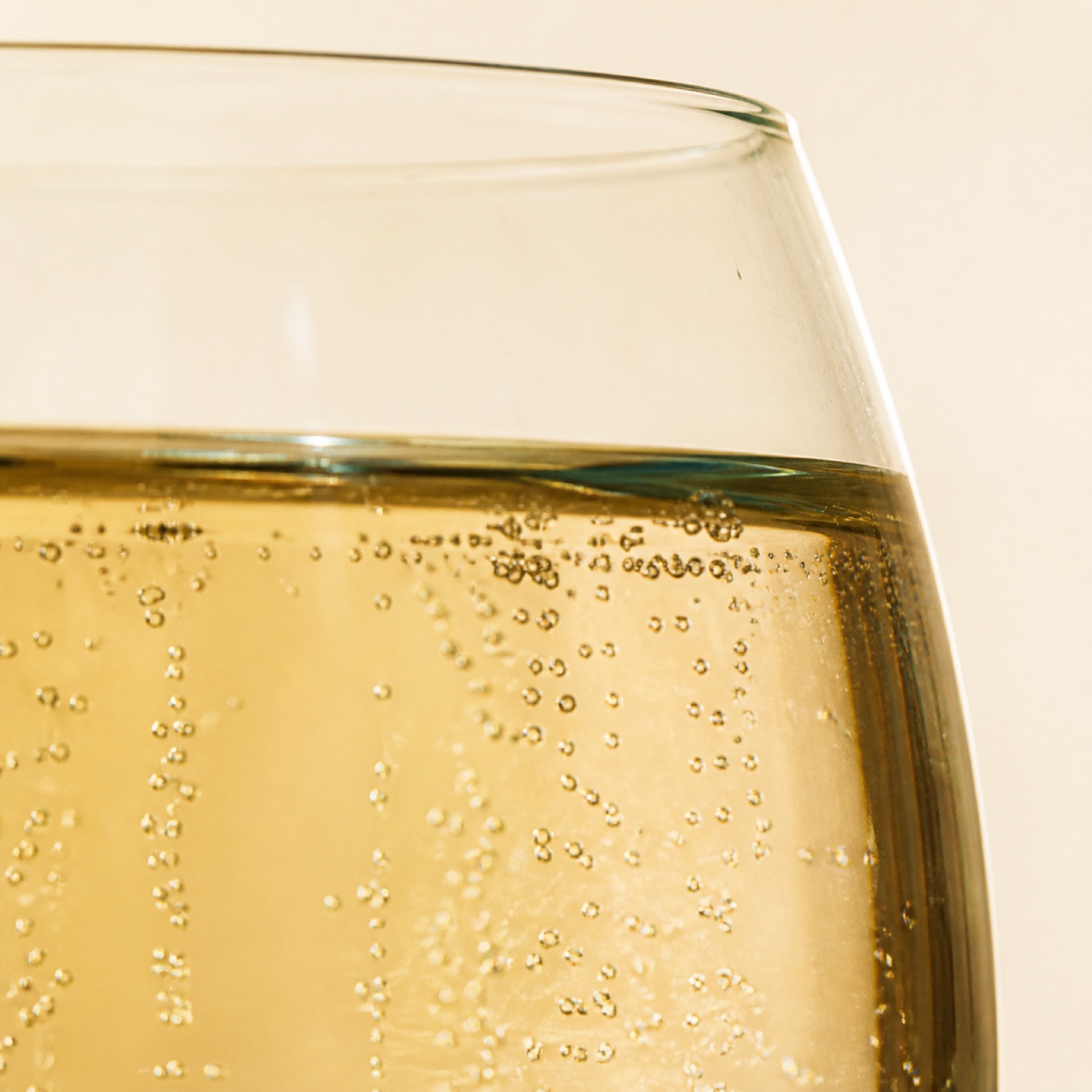 Detail van fijne bubbels in een glas licht-gouden botanische drank